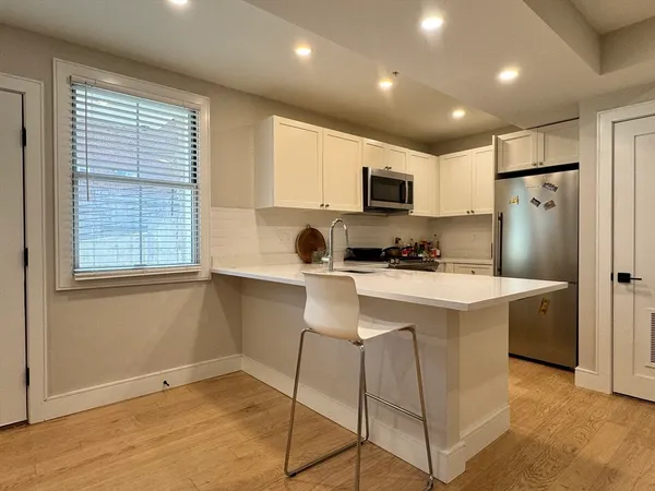 a kitchen with kitchen island a refrigerator stove and microwave