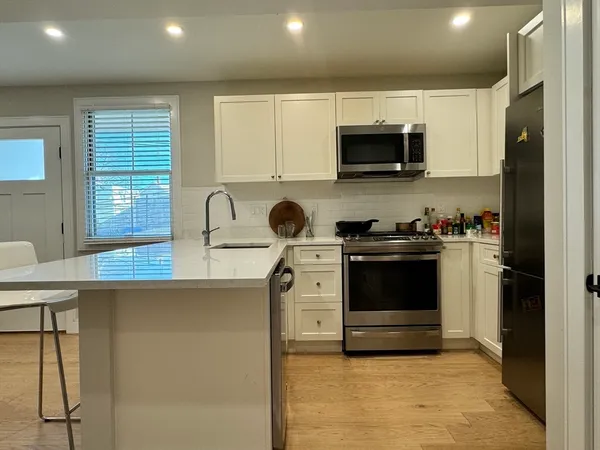 a kitchen with stainless steel appliances granite countertop a stove a sink and a microwave