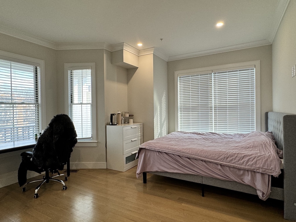 13 Greylock Road, Unit 1 Boston, MA 02134 - Photo 7 of 11 a bedroom with a bed and a chair