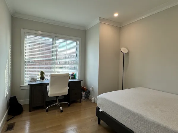 a bedroom with a bed a table and a window