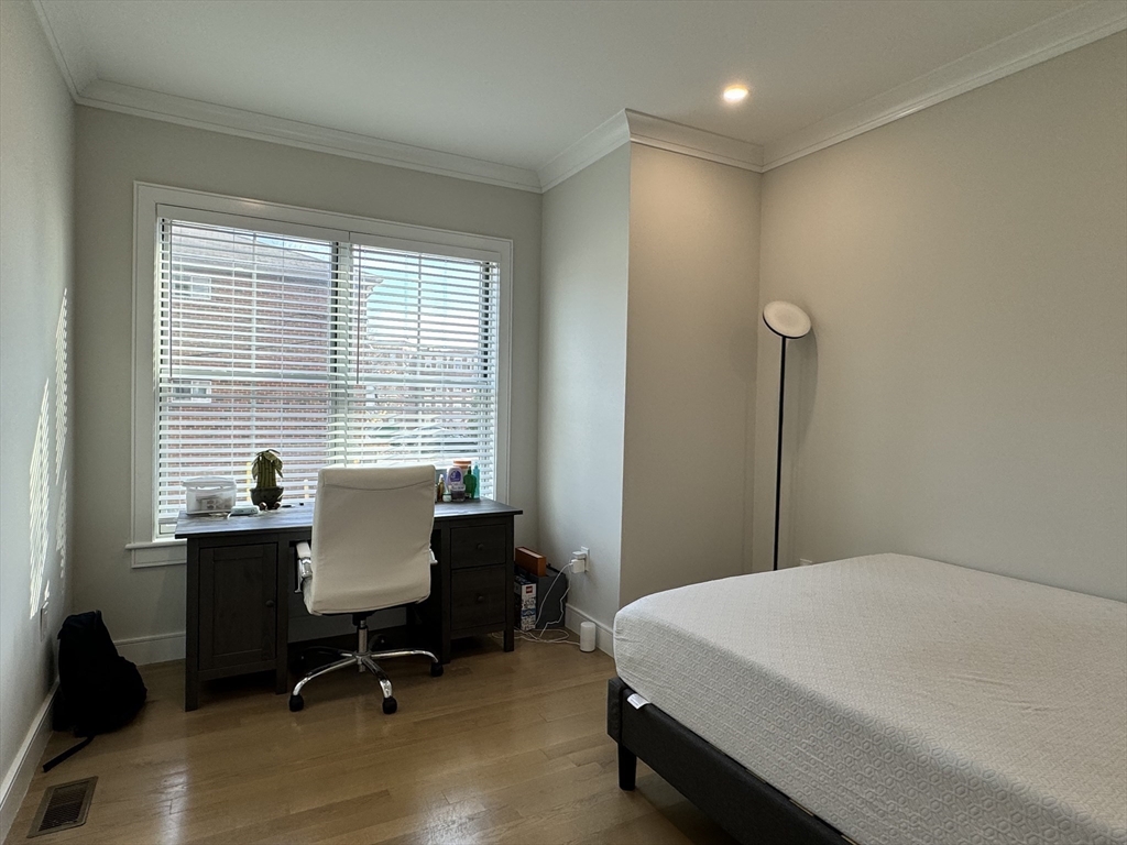 13 Greylock Road, Unit 1 Boston, MA 02134 - Photo 8 of 11 a bedroom with a bed a table and a window