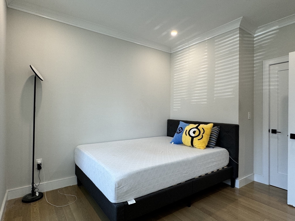 13 Greylock Road, Unit 1 Boston, MA 02134 - Photo 9 of 11 a bedroom with a bed and wooden floor