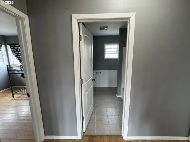 a view of a hallway with wooden floor and entryway