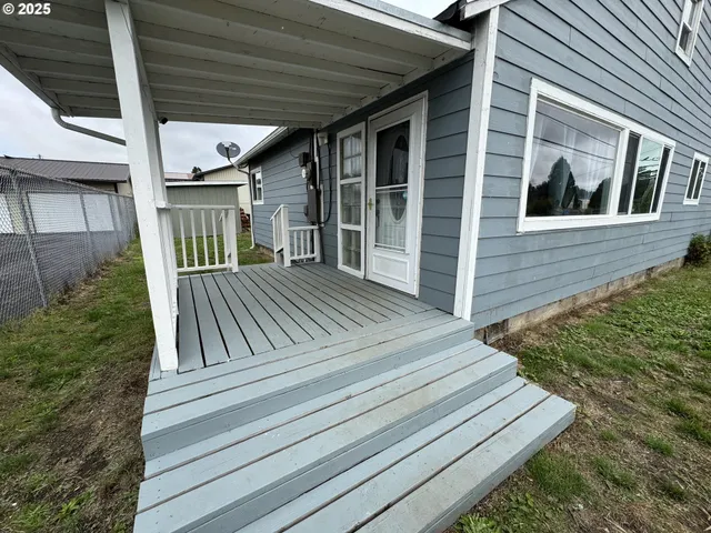 a view of backyard with wooden deck and floor to ceiling window