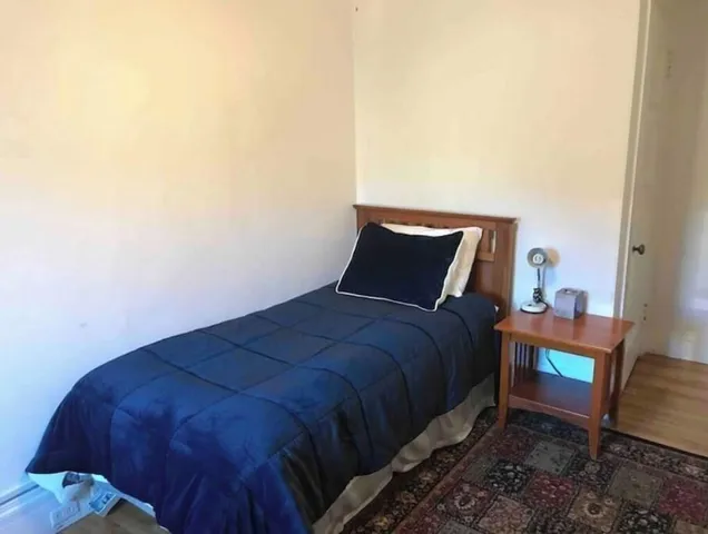 a bed sitting in a bedroom next to a window