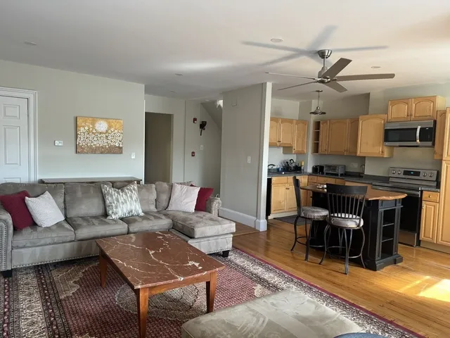 a living room with furniture and kitchen view