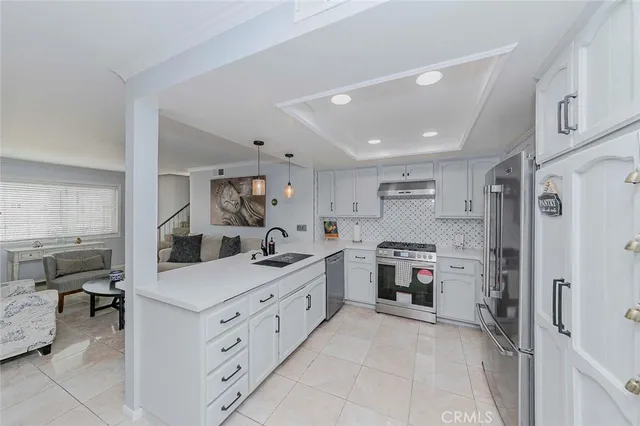 a kitchen with stainless steel appliances kitchen island granite countertop a sink and a refrigerator