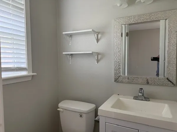 a bathroom with a sink toilet and mirror