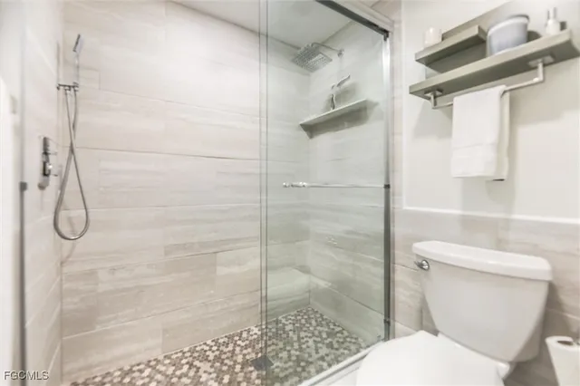 a white toilet next to a bathroom