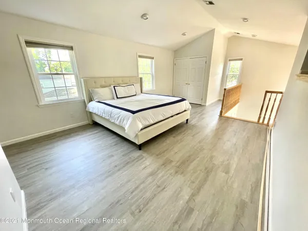 a large bed sitting in a bedroom next to a window