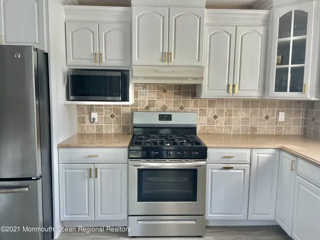 a kitchen with white cabinets and stainless steel appliances