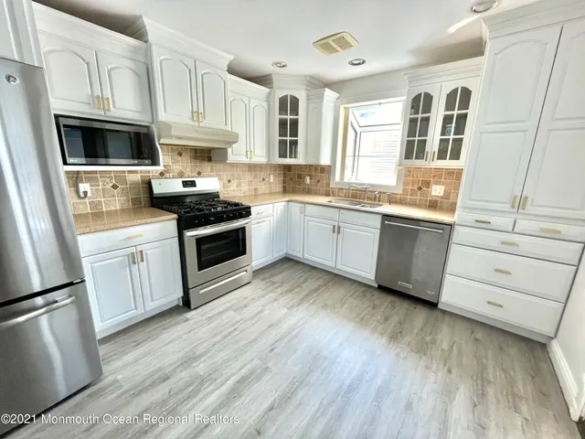 a kitchen with granite countertop white cabinets and white appliances