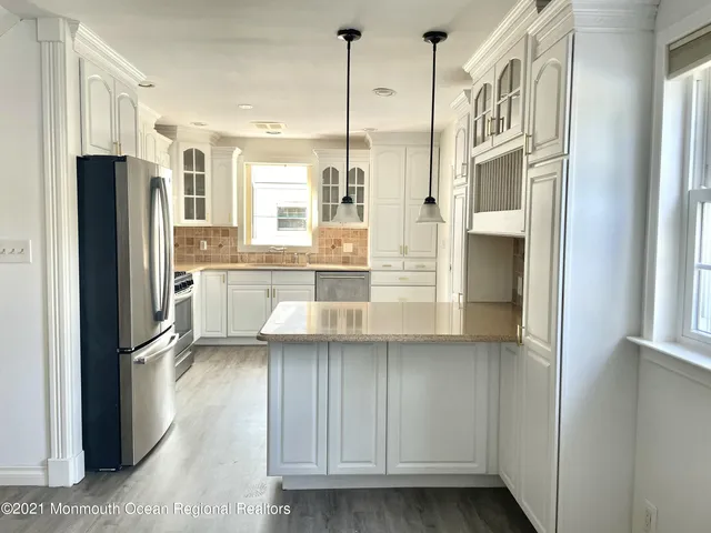 a kitchen with stainless steel appliances granite countertop a refrigerator a sink and a stove