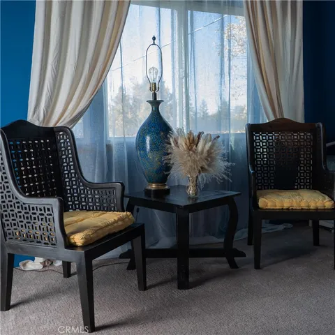 a living room with fireplace furniture and a large window