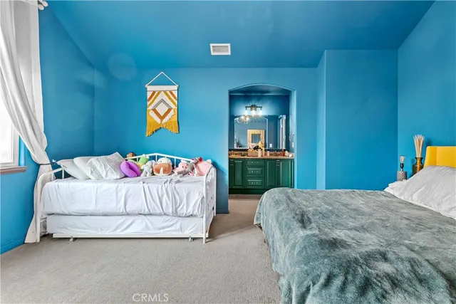 a bedroom with a large bed and a chandelier