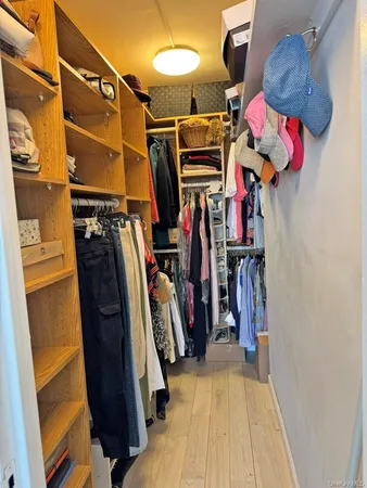 a view of walk in closet with clothes and shoes