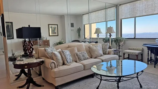 a living room with furniture a flat screen tv and a large window