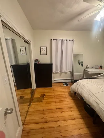 a bedroom with bed and wooden floor