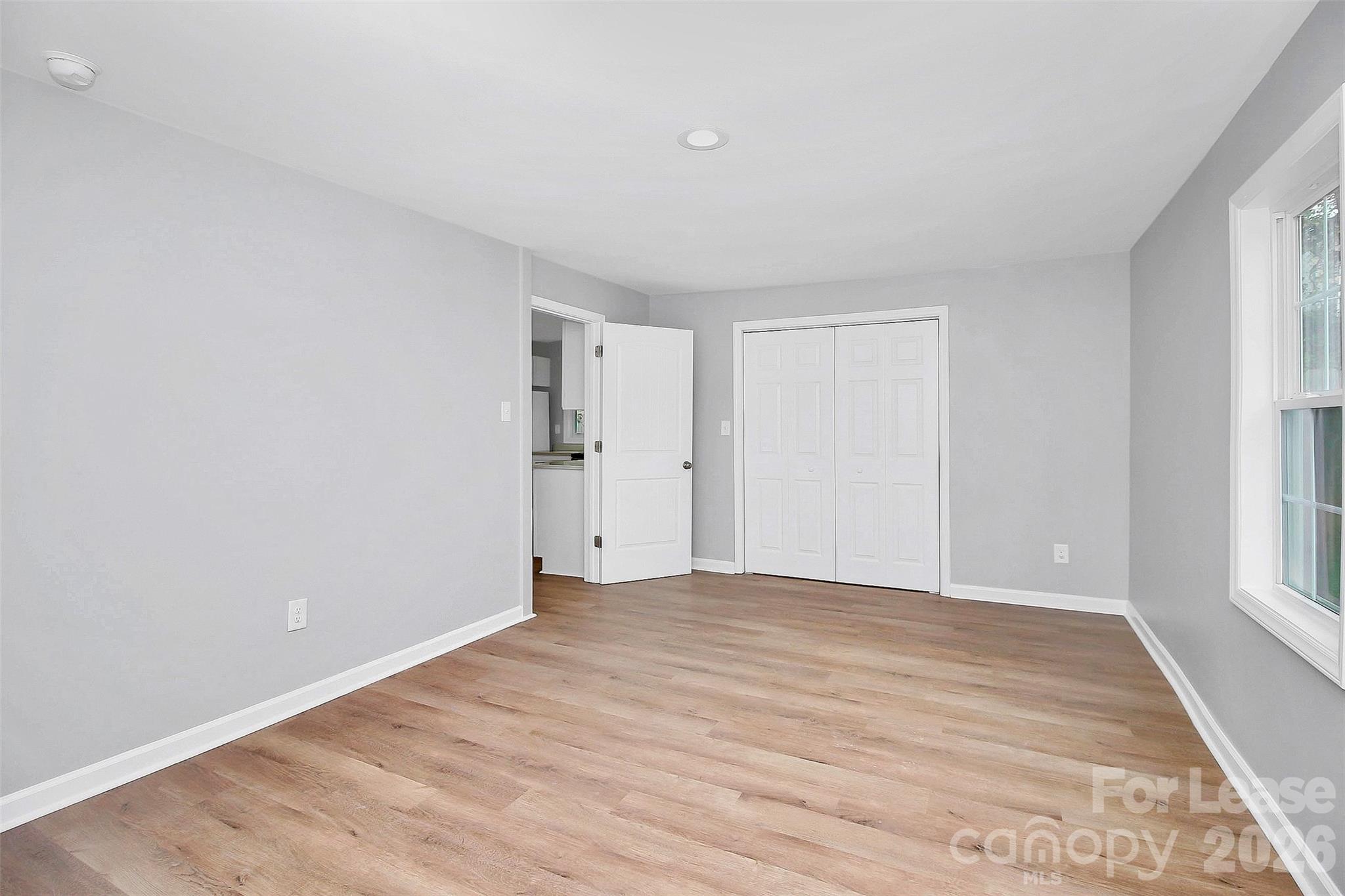 315 South Ransom Street Gastonia, NC 28052 - Photo 5 of 18 a view of an empty room with wooden floor and a window