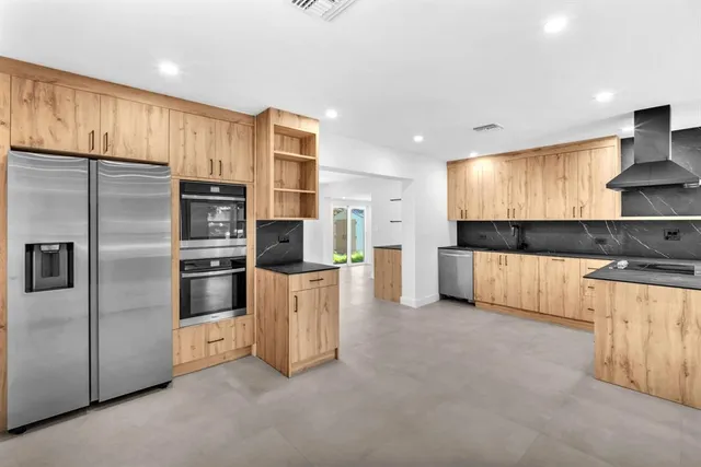 a view of kitchen with refrigerator and window