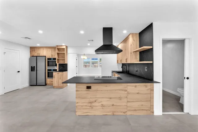 a large kitchen with stainless steel appliances kitchen island a large counter top and a stove