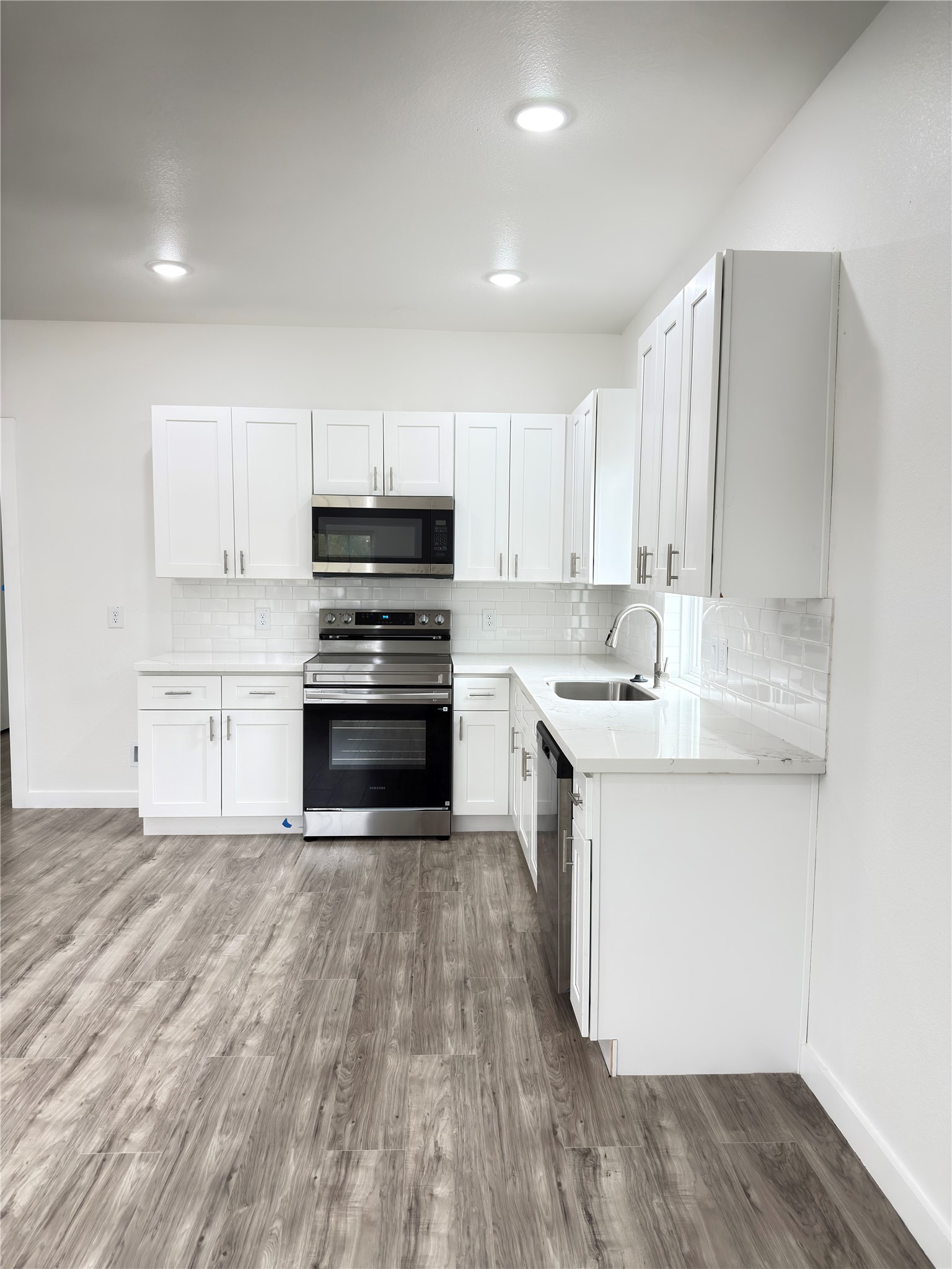 Modern open-concept kitchen seamlessly connects to the dining area, with the added convenience of a half bath on the main level.
