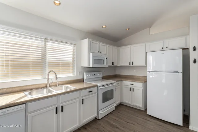 a kitchen with granite countertop white cabinets and white appliances
