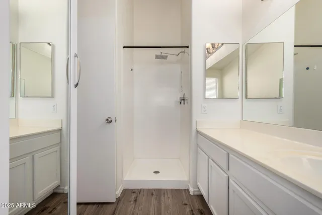 a bathroom with a double vanity sink toilet mirror and bathtub