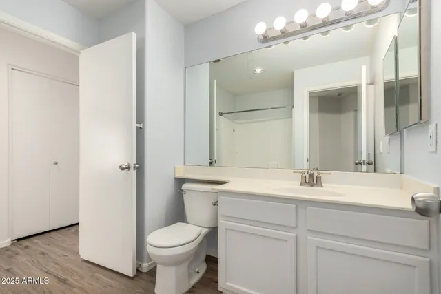 a view of an empty room with wooden floor and closet