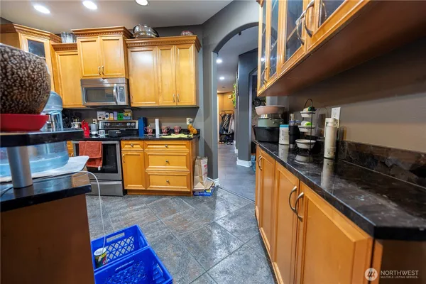 a kitchen with stainless steel appliances granite countertop a stove a sink and a microwave