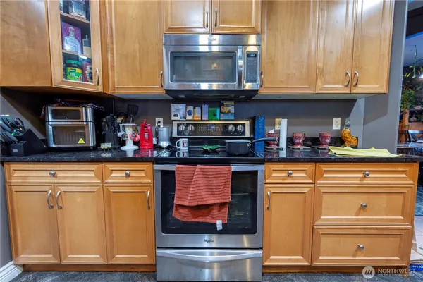 a kitchen with stainless steel appliances granite countertop a stove and cabinets