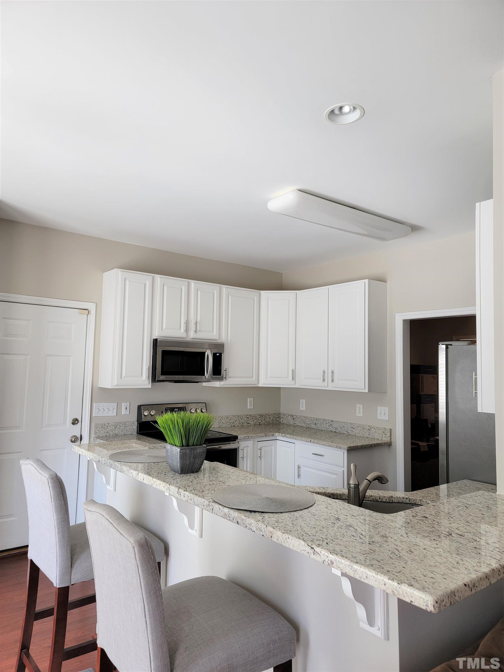 3301 Bellenden Place Raleigh, NC 27604 - Photo 10 of 30 a kitchen with granite countertop a sink and a stove top oven