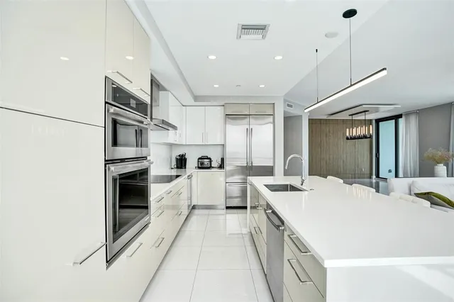 a kitchen with white cabinets and appliances