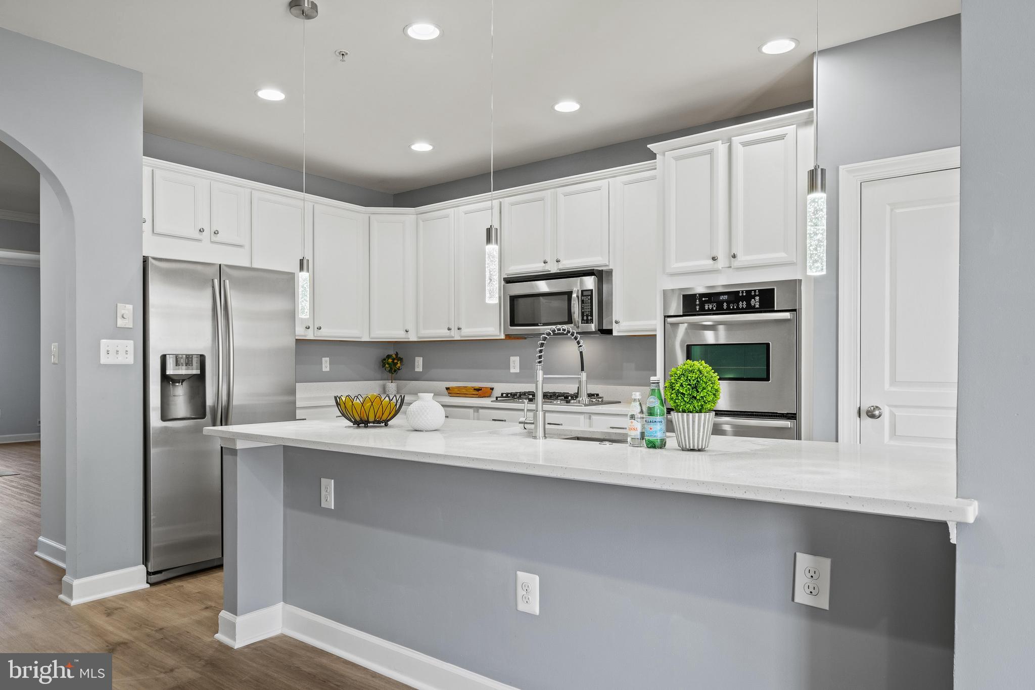 7704 Water Street Fulton, MD 20759 - Photo 8 of 45 a kitchen with stainless steel appliances a sink a refrigerator and a counter top space