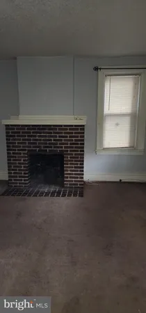 a view of empty room with window and fireplace