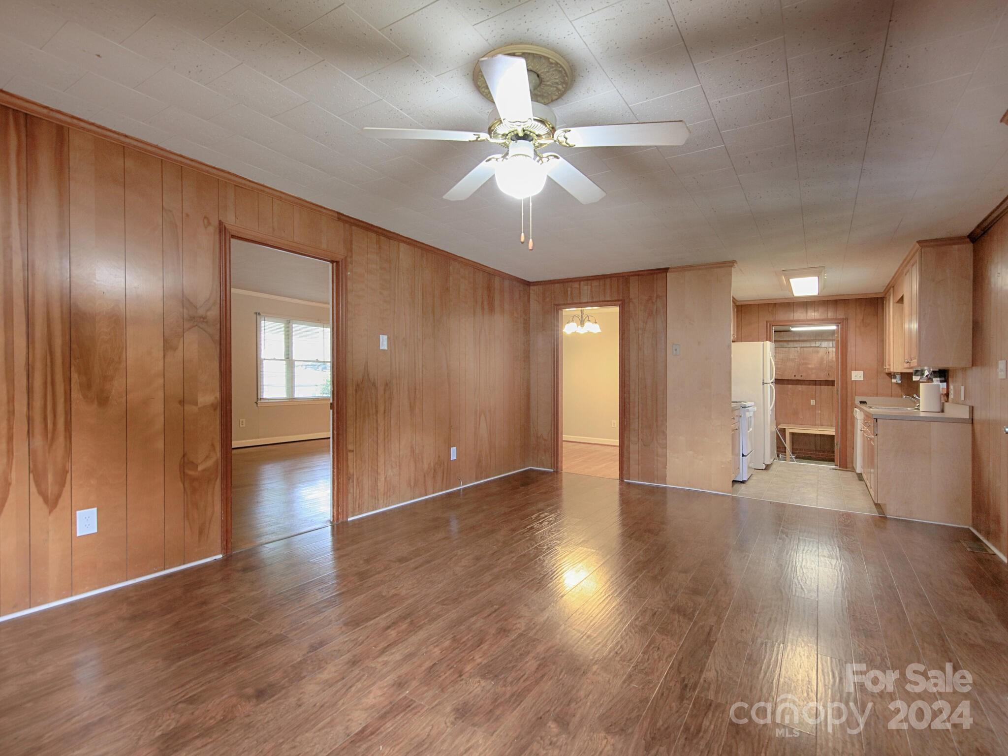 446 Fieldstone Road Mooresville, NC 28115 - Photo 14 of 30 a view of an empty room with wooden floor and a kitchen