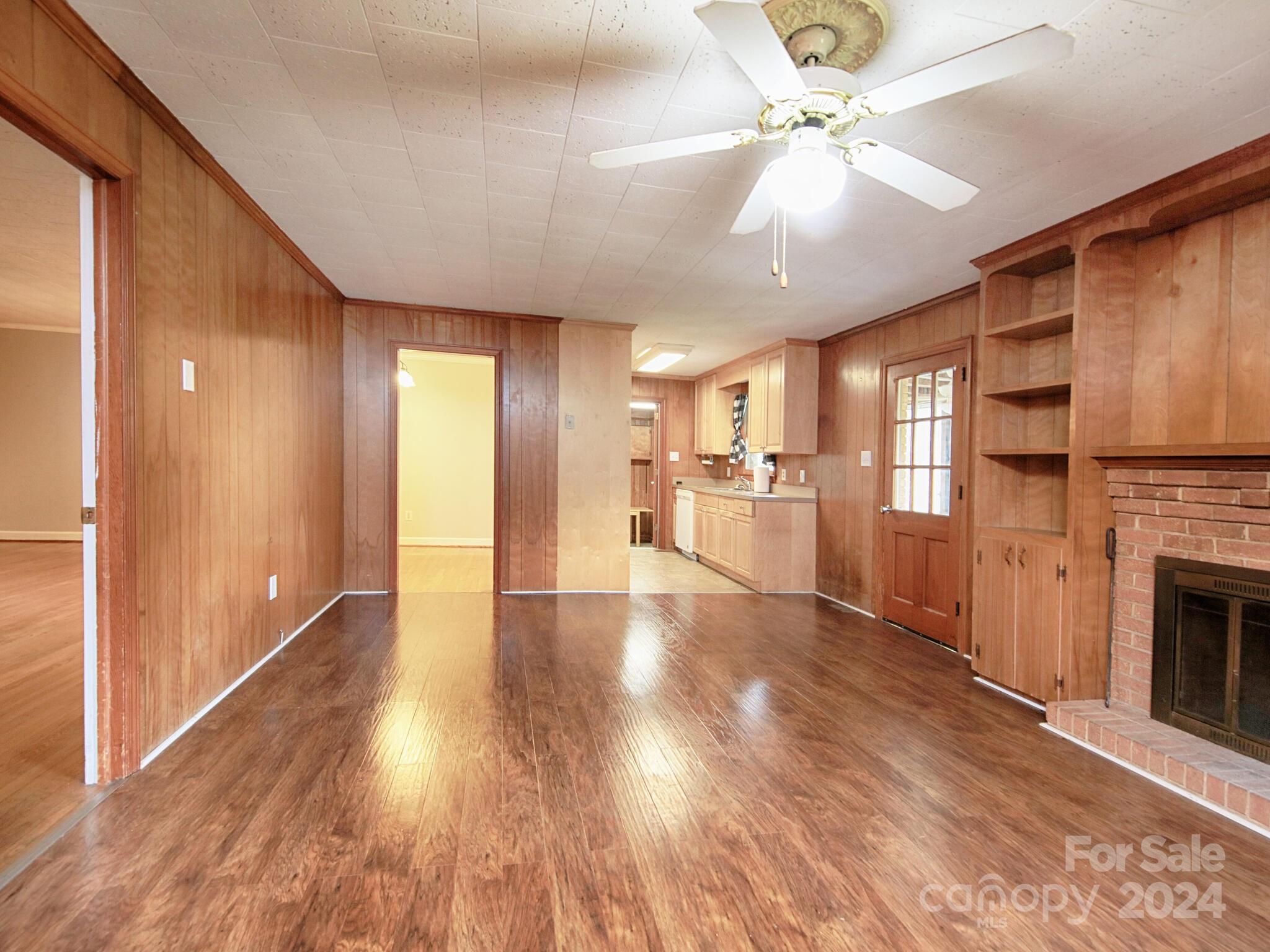 446 Fieldstone Road Mooresville, NC 28115 - Photo 15 of 30 a view of a livingroom with furniture a fireplace a ceiling fan and wooden floor