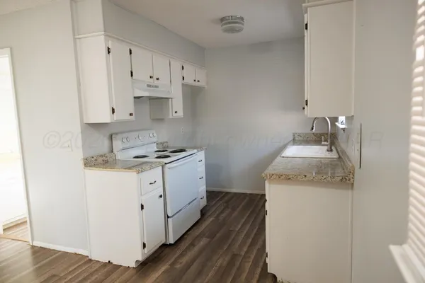 a kitchen with granite countertop white cabinets and white appliances