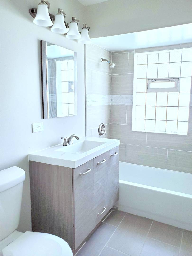 6106 Birmingham Street Chicago Ridge, IL 60415 - Photo 12 of 31 a bathroom with a tub sink and mirror