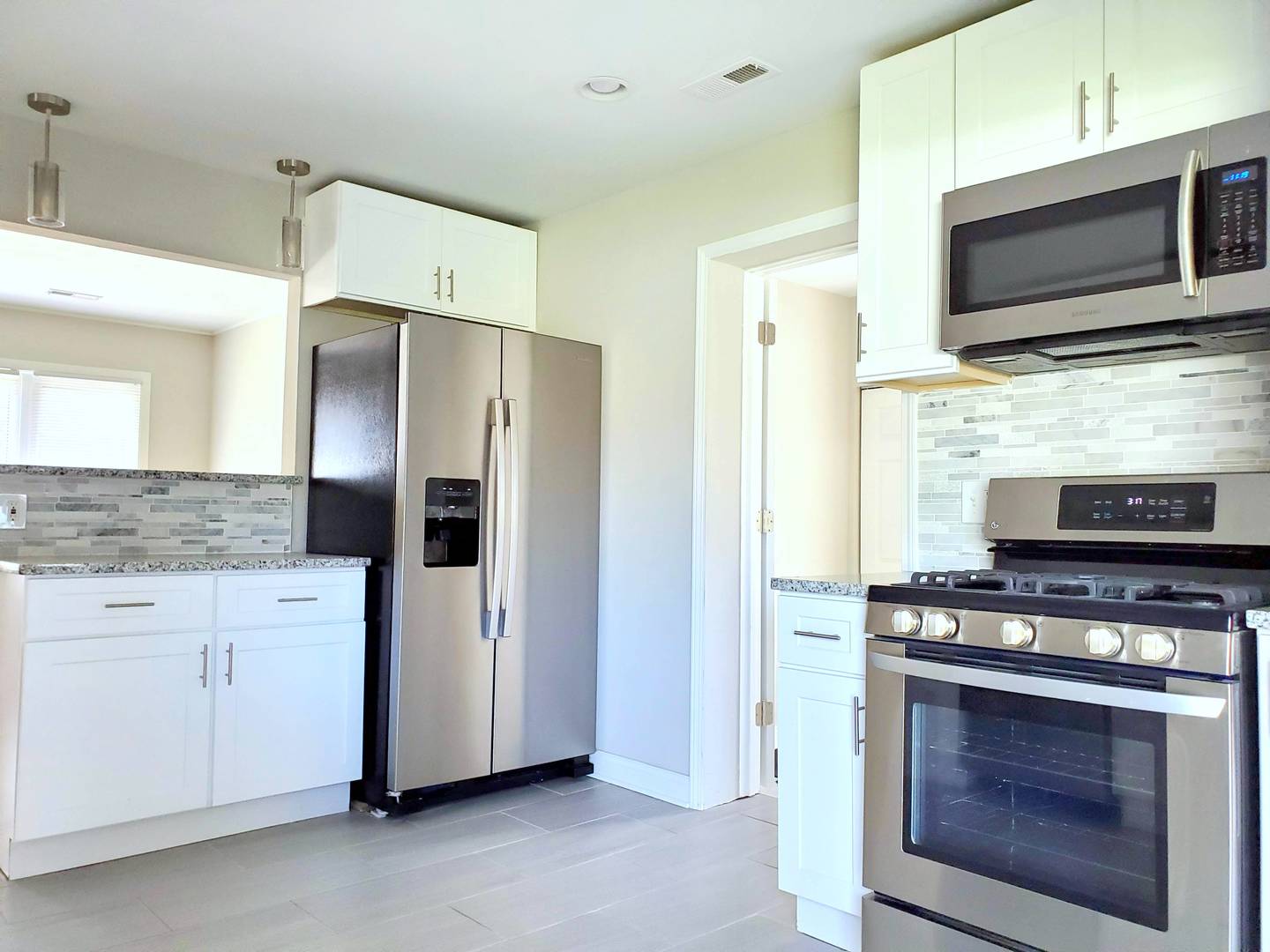 6106 Birmingham Street Chicago Ridge, IL 60415 - Photo 7 of 31 a kitchen with stainless steel appliances a stove a microwave and a sink