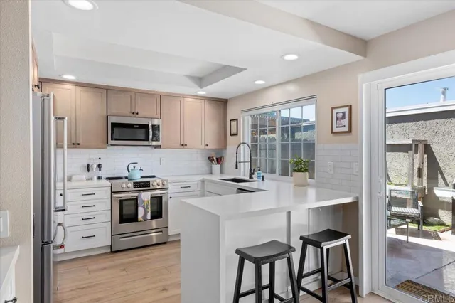 a kitchen with a stove a sink a microwave and cabinets