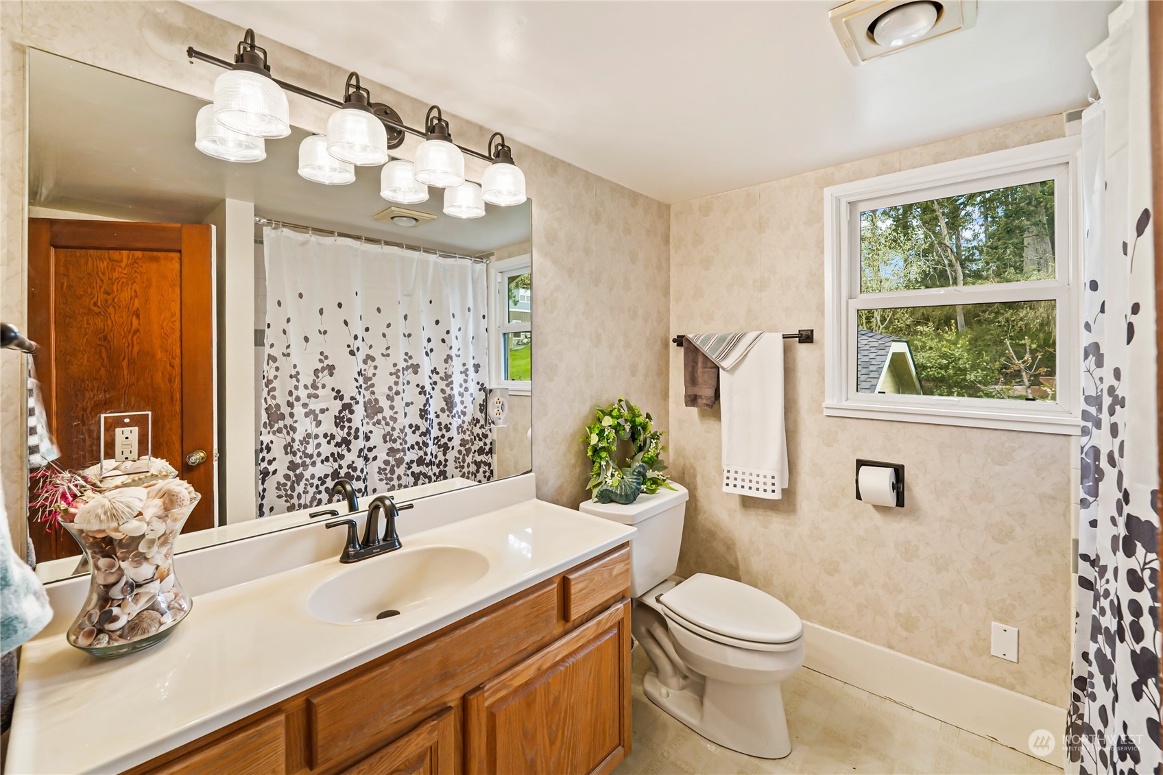 5918 Sunset Avenue Anacortes, WA 98221 - Photo 25 of 38 a bathroom with a sink a toilet a mirror a vanity and shower