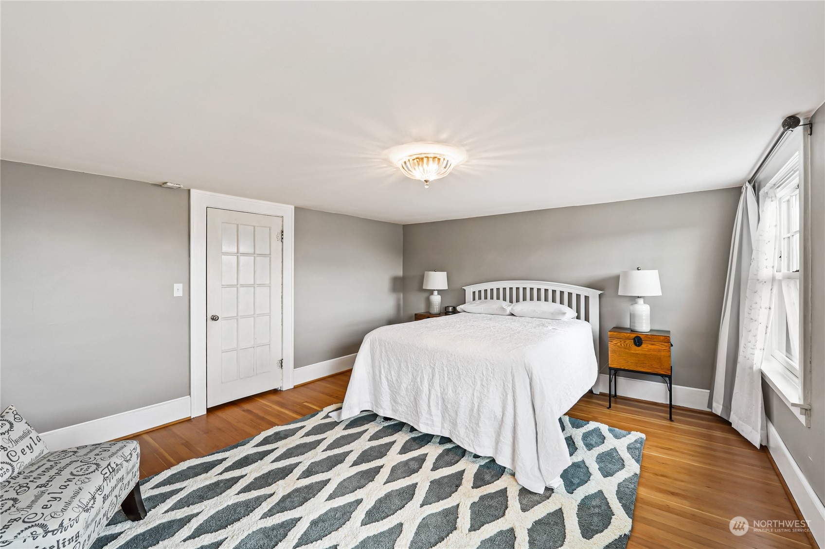 5918 Sunset Avenue Anacortes, WA 98221 - Photo 30 of 38 a bedroom with a bed and wooden floor