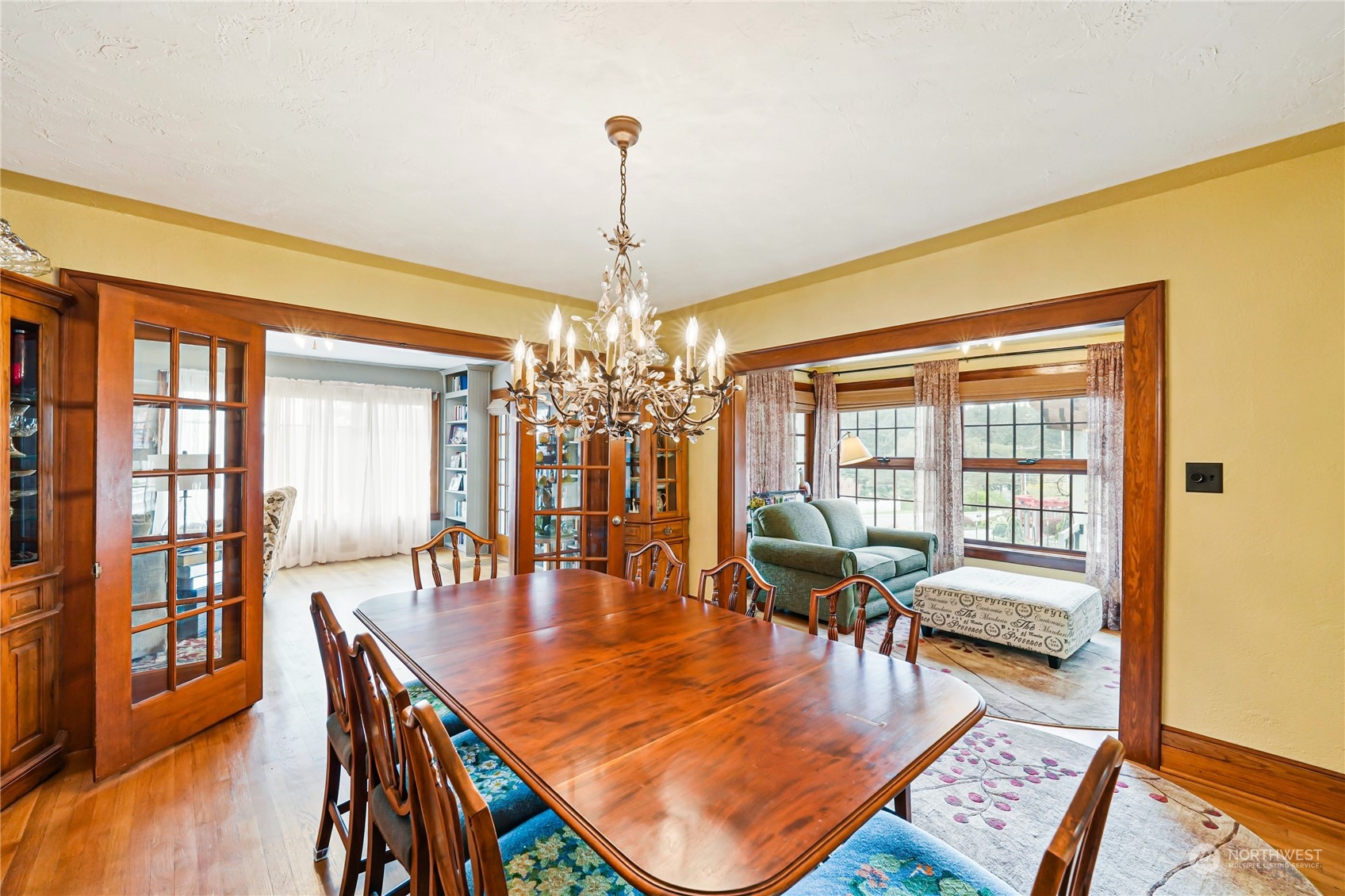 5918 Sunset Avenue Anacortes, WA 98221 - Photo 10 of 38 a dining room with wooden floor a chandelier a wooden table and chairs