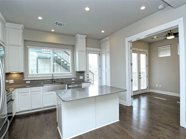 a large kitchen with lots of counter space sink and a window