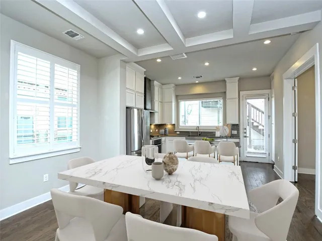 a living room with stainless steel appliances furniture a window and kitchen view