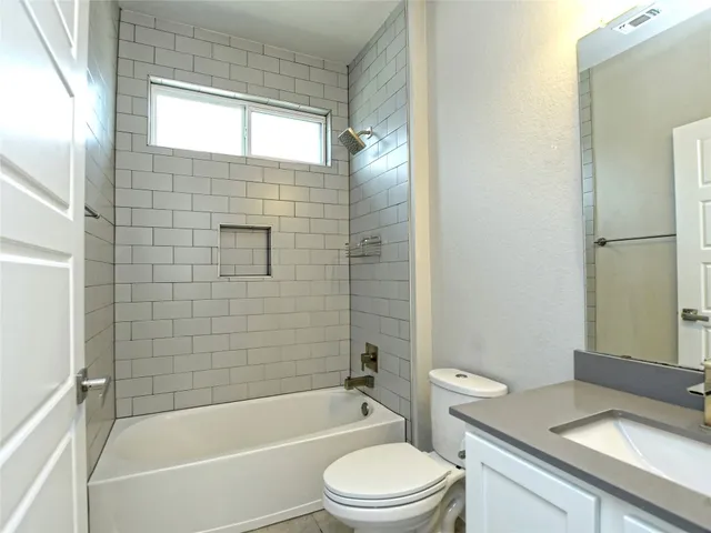 a bathroom with a granite countertop bathtub toilet and sink