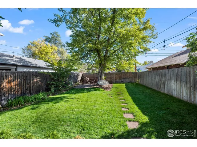 a view of backyard with table and chairs and potted plants