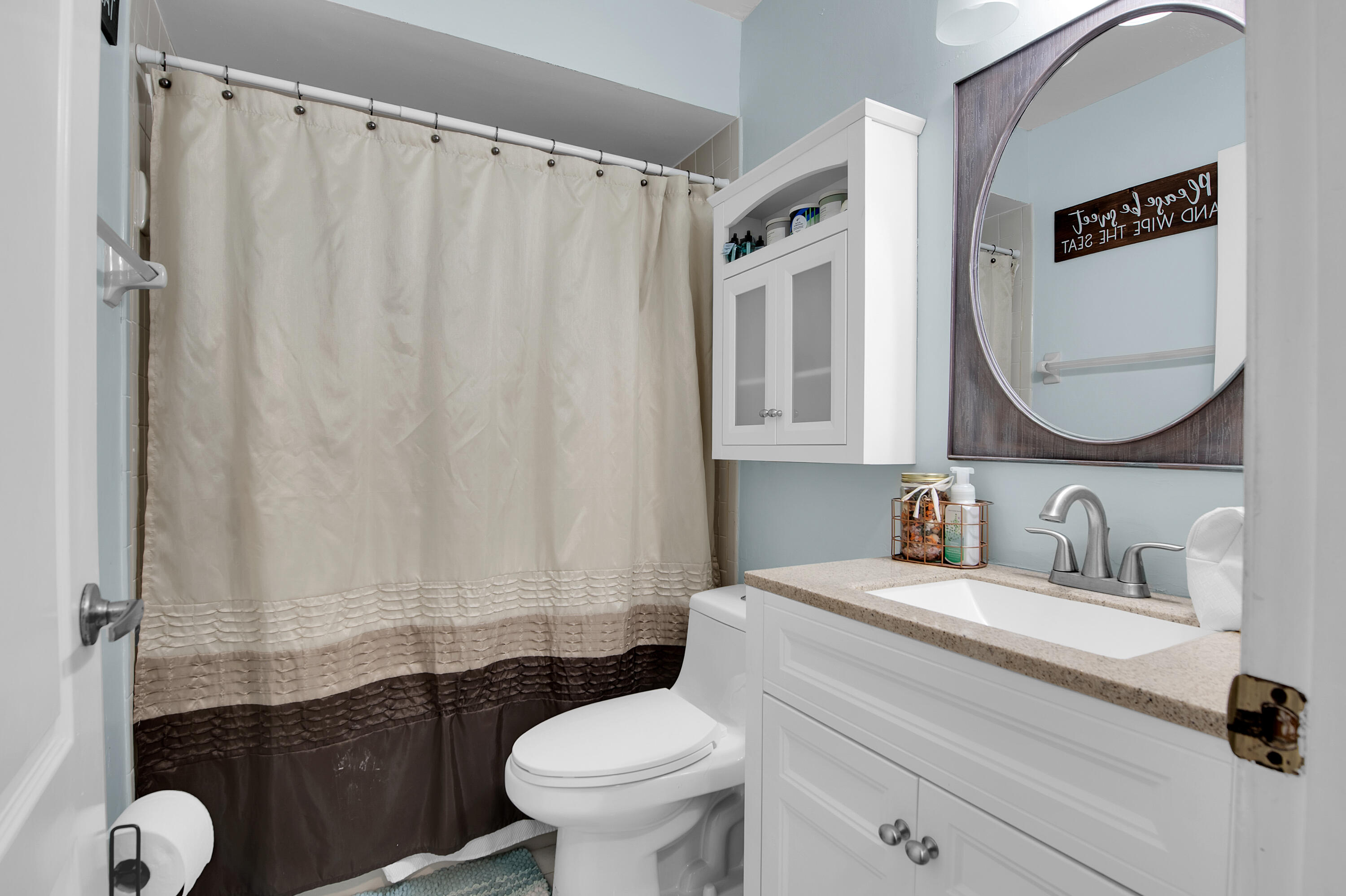 8203 Northwest 100th Way Tamarac, FL 33321 - Photo 17 of 31 a bathroom with a toilet sink and mirror
