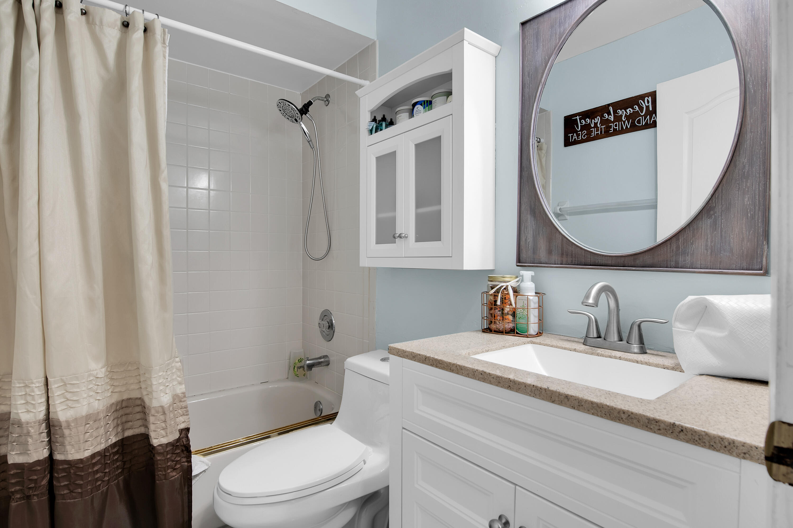 8203 Northwest 100th Way Tamarac, FL 33321 - Photo 18 of 31 a bathroom with a sink a toilet and a mirror